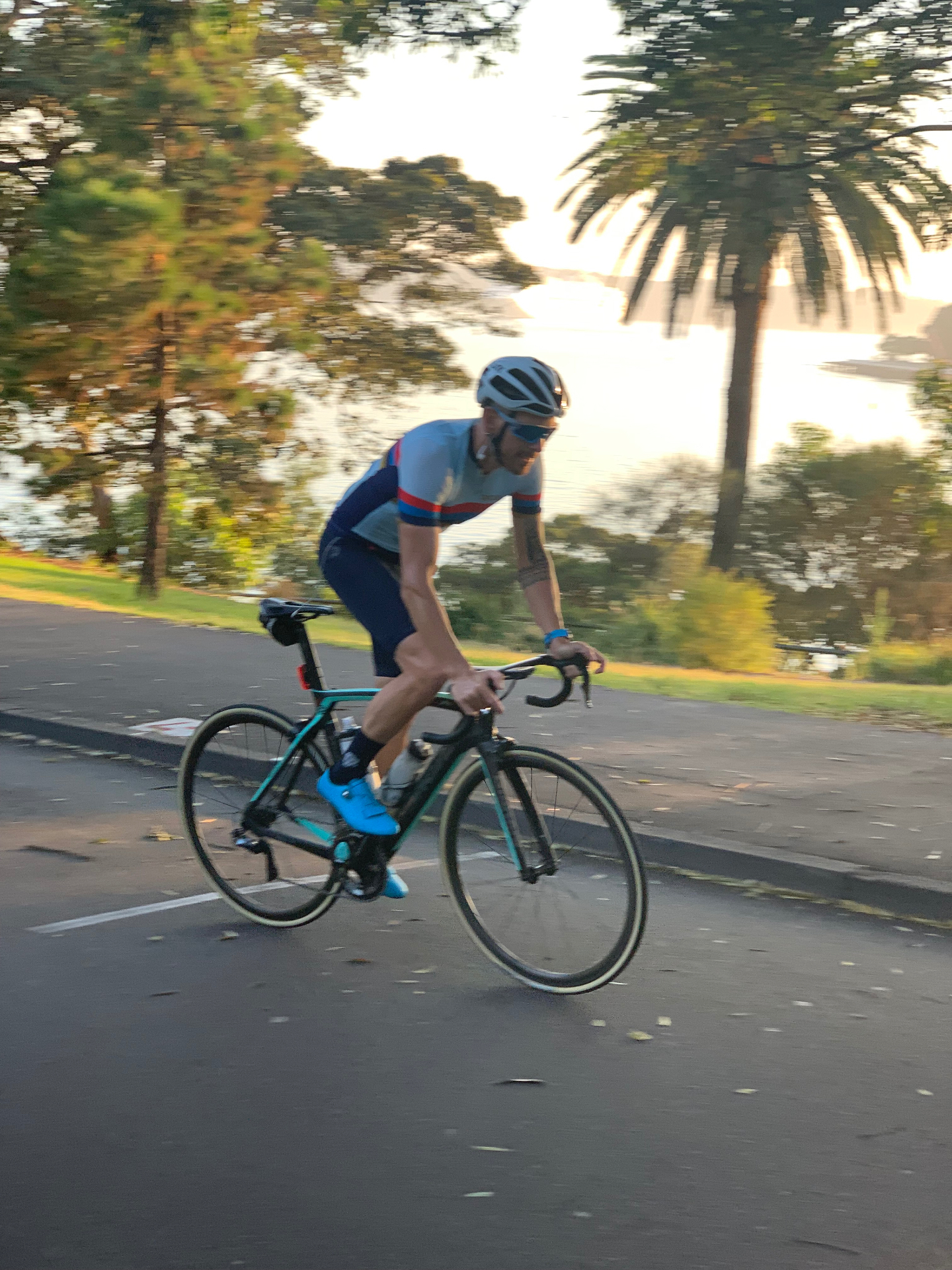 Phillipe cycling beside the water at sunrise