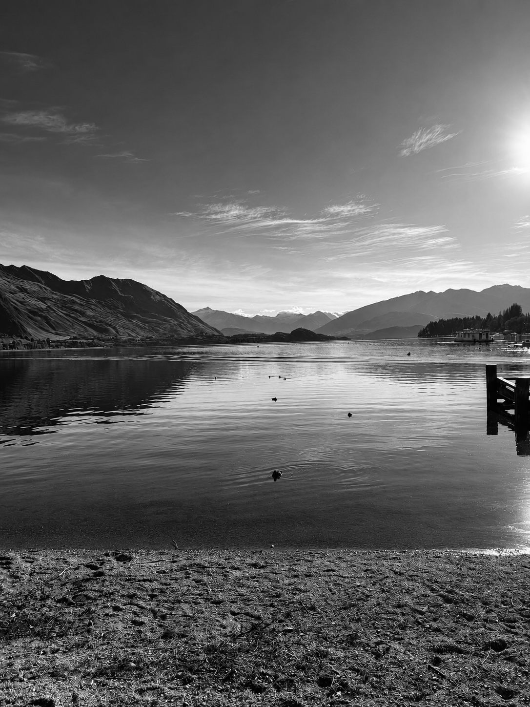 Still lake and mountains at sunrise in black and white